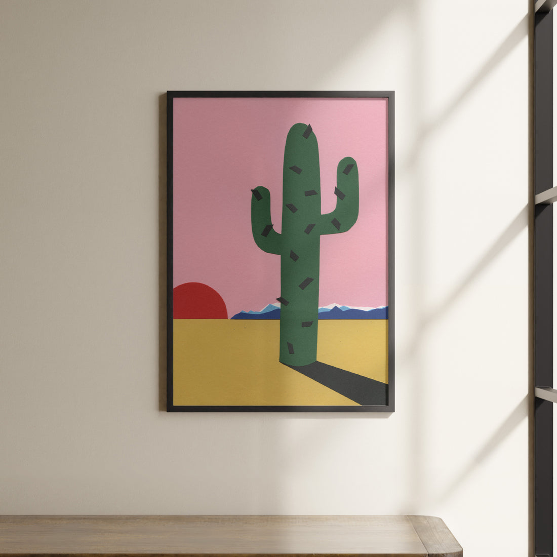 a painting of a cactus hangs on a wall